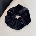 Detail shot of a black velvet scrunchie showing soft pleated texture and premium fabric gloss - Velvet Edge Scrunchie - Black