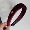 Close-up of burgundy velvet padded headband showing the handmade label and gold logo - Burgundy