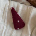Dettaglio di un fermaglio per capelli in feltro bordeaux a pois bianchi su fondo di lino - Triangolo Grande Rosso