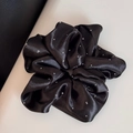 Macro view of silky black satin scrunchie featuring shimmering silver rhinestone details - Oversized Style / Black