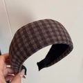 Detail eines braunen karierten Flanell-Stirnbands mit dicker Textur und schwarzem Futter - Braun