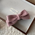 Detalle de pinza para el pelo con lazo de punto rosa, botón dorado y textura firme - Clip de Plátano con Lazo de Pana / Rosa