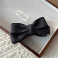 Detalle de una pinza para el pelo con lazo de pana gris y placa metálica dorada elegante - Clip de Plátano con Lazo de Pana / Gris