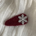Dettaglio di un fermaglio per capelli in peluche rosso con fiocco di neve e perla - Stile Goccia d'Acqua / Borgogna