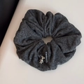 Detalle de coletero de tela gris oscuro con colgante de oso plateado y etiqueta moda - Coletero de Oso Plateado / Gris