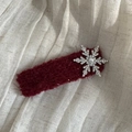 Dettaglio macro di un fermaglio in peluche rosso vino con fiocco di neve argento e strass - Stile Rettangolo / Borgogna