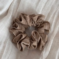 Close-up of brown plaid scrunchie with cotton linen texture and Hand Made fabric label - Brown