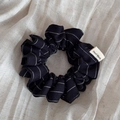Close-up of black striped hair scrunchie with a handmade woven label on linen fabric - Navy Blue