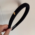 Detailansicht eines schwarzen Stoffstirnbands mit goldenem Hund und Handmade-Label - Schwarz