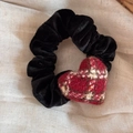 Detailed texture of black corduroy scrunchie with red plaid heart ornament on beige fabric - Black Velvet Red Plaid Heart Scrunchie