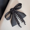 Gros plan d'une pince à cheveux à nœud gris anthracite avec perles et tissu peluche - Pince Banane
