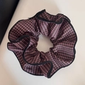 Vue détaillée du chouchou à carreaux marron vintage avec des bords à volants noirs - Plaid Rose
