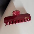 Détail d'une pince à cheveux bordeaux brillante avec lettrage doré Barrette LaFrance - Pince Rectangulaire / Rouge