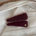 Dettaglio di due fermagli per capelli in peluche rosso scuro con lettera B dorata su lino - Lettera Peluche BB - Triangolo Sottile Rosso