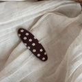 Detail of a brown floral fabric covered snap hair clip on a minimalist linen background - Brown Floral Oval Clip