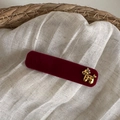 Detalle de horquilla de terciopelo rojo oscuro con dije metálico de caniche dorado - Clip Pony Terciopelo Rojo