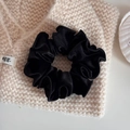 Detailed view of black velvet scrunchie texture on a soft beige knitted fabric background - Velvet Pleated Small Circle-Black