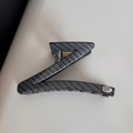 Detailed close-up of dark grey carbon fiber texture on Z-shaped hair claw clip with handmade tag - Z-Shaped