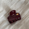 Gros plan d'une pince à cheveux bordeaux avec un emblème Love doré sur tissu - Petite Pince Rectangulaire Étiquette Dorée / Rouge