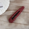Dettaglio di un fermaglio per capelli in tessuto scozzese rosso su tessuto beige - Goccia d'Acqua Lunga Traforata (Quadretti Rossi)