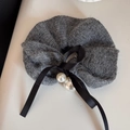 Dettaglio dell'elastico per capelli grigio a maglia con fiocco nero e perle bianche - Grigio