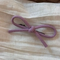 Détail de la pince à cheveux nœud en laine violette sur tissu plissé beige doux - Grande Pince Bec de Canard Nœud en Laine / Violet