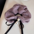 Dettaglio dell'elastico in maglia viola con texture mohair, nastro nero e perle grandi - Viola