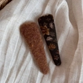 Detail von geblümten BB-Haarspangen und braunen Filz-Clips auf beigem Stoff - Blumen Gelbgrün Dreieck Stil