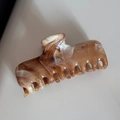 Detailed top view of a marbled brown and white shark hair claw clip with acetate texture - Large Coffee