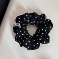 Detailaufnahme von schwarzem gepunktetem Stoff Stirnband mit Love From Seoul Webetikett - Schwarz Punkte Haargummi