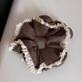 Detailed macro view of brown knit scrunchie featuring white double-layer lace edges - Brown