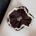 Detailed view of brown knit fabric and white crochet lace trim on the hair scrunchie - Brown