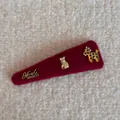 Dettaglio di un fermaglio per capelli in feltro bordeaux con ciondoli dorati fatti a mano - Rosso Capodanno Triangolo - Cavallo Sacco Fortuna