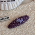 Dettaglio macro di un fermaglio in tweed viola con un simpatico cucciolo color lavanda - Stile Cavallino Piccolo Ovale Tweed Viola