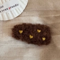 Detail van koffiekleurige pluche hartvormige haarklem op een linnen achtergrond - Donker koffiebruin