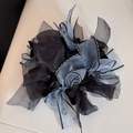 Detail of multi-layered black and silver organza fabric on this oversized hair scrunchie - Blue