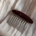 Close-up of a brown polka dot fabric hair comb with silver metal teeth on linen - Coffee Polka Dot (Oval Hair Comb)