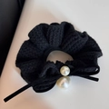 Vue détaillée d'un chouchou en maille noire avec perles blanches et nœud en ruban élégant - Noir