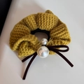 Détail du chouchou en tricot jaune gingembre avec perles blanches et nœud en velours brun - Jaune