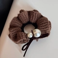 Détail d'un chouchou en maille marron avec perles et nœud en velours doux - Marron