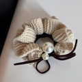 Détail d'un chouchou en maille beige avec perles blanches et nœud en ruban marron - Blanc Cassé