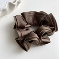 Détail d'un chouchou en satin marron foncé avec plis élégants et texture brillante soyeuse - Marron