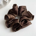 Détail d'un chouchou en satin marron foncé avec plis superposés et texture soyeuse - Café Foncé