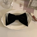 Détail du nœud élégant en velours marron et satin gris sur une assiette vintage - Pince à Cheveux Nœud Menthe Chocolat