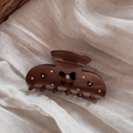 Detailed view of a brown bow hair claw clip with rhinestones on beige linen fabric - Coffee Bow (Medium)