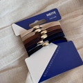 Detail view of 5 high-elastic hair ties in neutral colors with golden oval beads - Basic Gold Clasp Flat Black Coffee Group