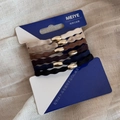 Close-up of 6 elastic hair ties with gold oval metal buckles on neutral textured fabric - Lotus Gold Clasp Thin Coffee Group