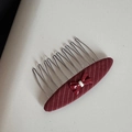 Dettaglio di un pettine per capelli con fiocco rosso, tessuto bordeaux e denti in metallo - Pettine per Capelli Ovale a Righe
