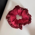 Dettaglio di scrunchie in velluto rosso scuro con bordi a balze plissettate e texture morbida - Elastico per Capelli con Volant a Righe