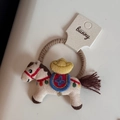 Detalle de coletero con caballo bordado, mini sombrero de paja y borla en banda elástica - Lazo para el Cabello Caballo de Lingote / Beige
